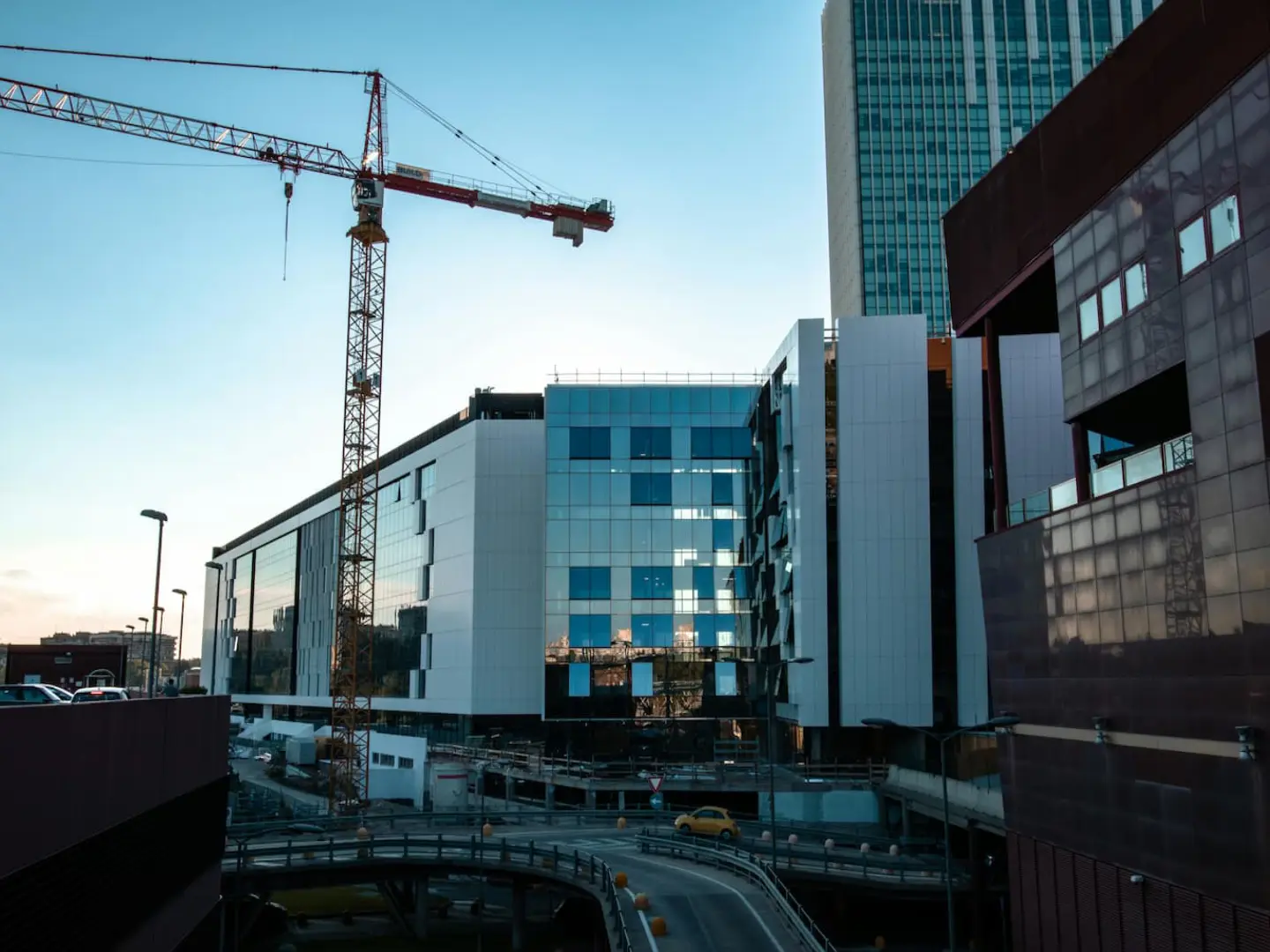 Commercial office buildings under construction beside a tower crane