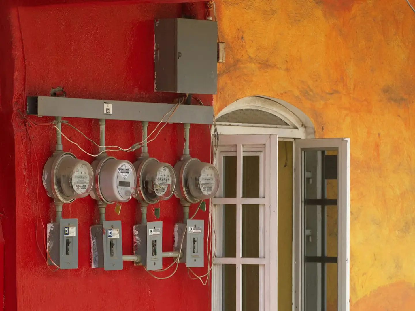 Row of electricity meters and disconnects on an exterior wall
