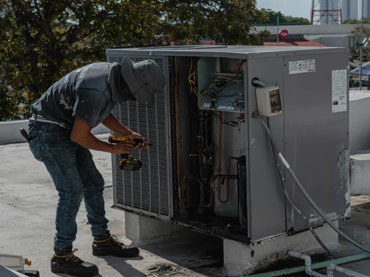 HVAC technician repairing an outdoor condenser unit